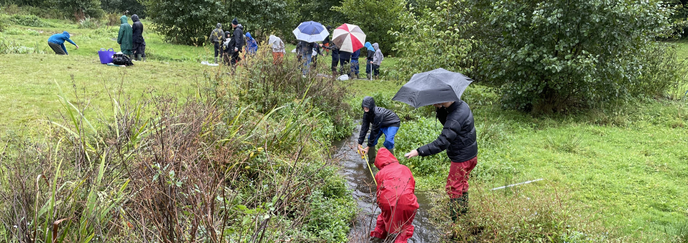 Veldwerk door leerlingen en docenten bij de Tillingbourne-rivier in het Verenigd Koninkrijk