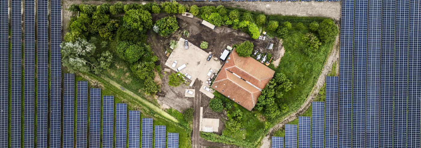 Luchtfoto van zonnepark Fledderbosch met een gebouw omringd door zonnepanelen
